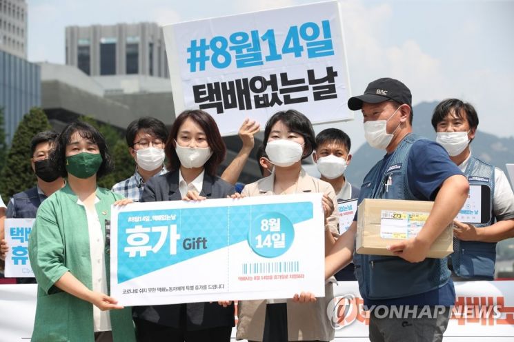 지난 9일 오전 서울 광화문광장에서 열린 '8월 14일을 택배없는 날로 지정하라!'기자회견에서 참석자들이 '인증샷 찍기 대국민운동 동참 및 택배노동자에게 휴가티켓 전달 퍼포먼스'를 하는 모습.사진=연합뉴스