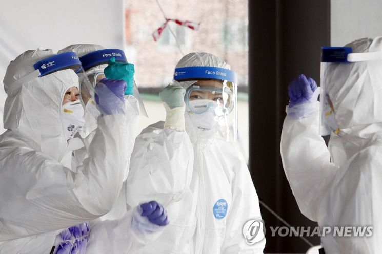 코로나19 치료 담당 의료진들이 카메라를 향해 미소를 보내고 있다. 사진=연합뉴스