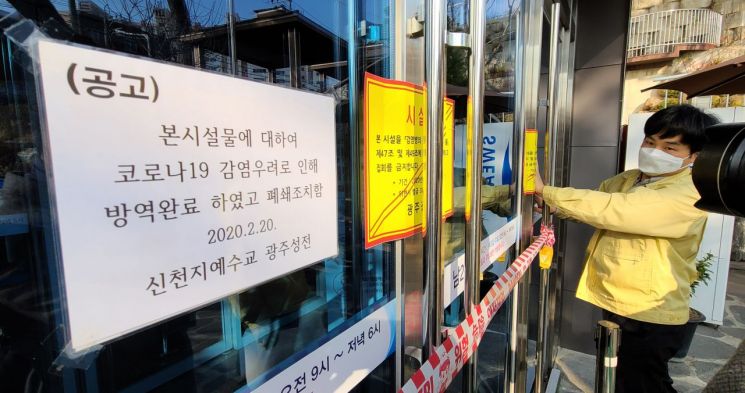 지난 2월27일 광주 북구 신천지 베드로 지성전(광주교회)에서 보건 당국 관계자가 출입문에 시설 폐쇄를 알리는 행정처분서를 붙이고 있다.<이미지:연합뉴스>