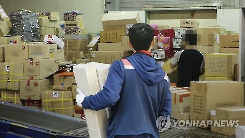 한 택배 기사가 배송 물건을 정리하고 있다. [이미지출처=연합뉴스]