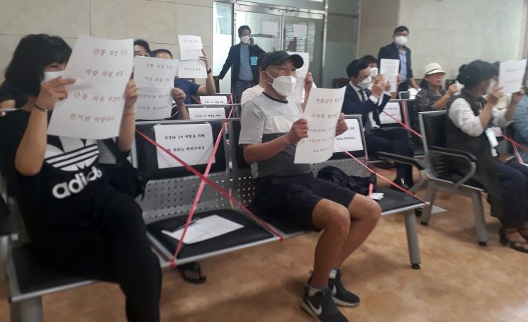 지난 16일 열린 전북 김제시의회 본회의장에서 시민들이 부적절한 관계로 물의를 빚은 의원들에 대한 제명을 요구하는 글을 들고 있다. [이미지출처=연합뉴스]