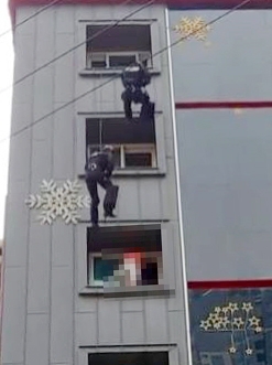 부산 북구의 한 모텔에서 투신 소동을 벌인 30대를 구조하는 경찰특공대.사진=연합뉴스