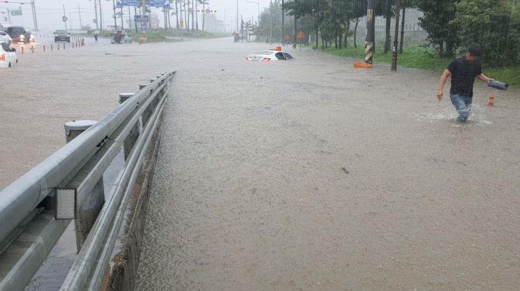 충남 천안에 3일 폭우가 쏟아진 가운데 시민들이 물에 빠진 차를 두고 급히 빠져나오고 있다. 사진=연합뉴스