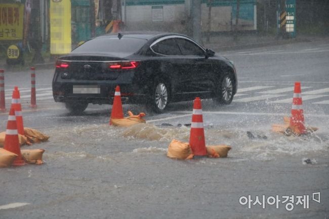 광주지역에 호우특보가 발효된 7일 오후 3시께 광주광역시 서구 화정동 한 도로 배수구가 파손돼 빗물이 역류하면서 도로 일대가 통제됐다.