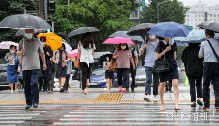 장마가 이어지고 있는 11일 서울 종로구 세종로 네거리에서 직장인들이 우산을 쓰고 출근길에 오르고 있다./강진형 기자aymsdream@