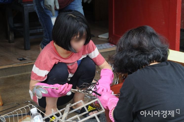 12일 전남 구례군 구례읍 봉동리 5일 시장에서 한 여학생이 침수 당한 물건을 닦고 있다.