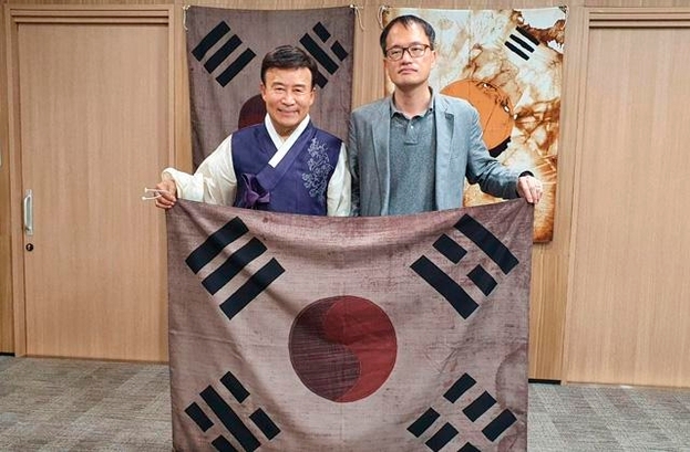 더불어민주당 박주민(오른쪽) 의원이 15일 서울 여의도 광복회관에서 김원웅 광복회장을 만나 태극기를 들고 있다. /박주민 의원실 제공 [이미지출처=연합뉴스]