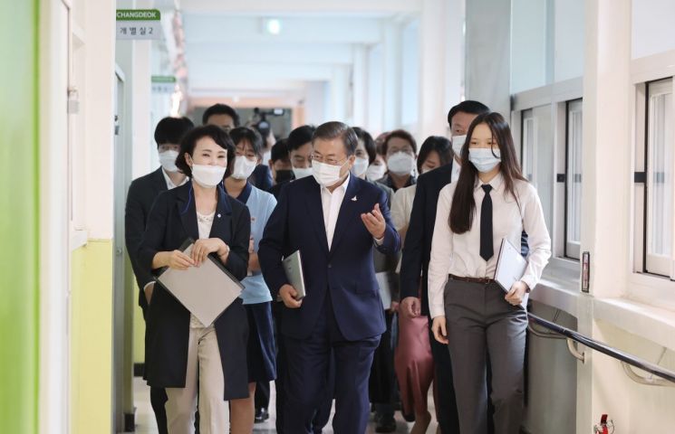 문재인 대통령이 18일 한국판 뉴딜 10대 과제 중 하나인 '그린 스마트스쿨' 현장인 서울 중구 창덕여중을 방문, 테크센터에서 수업에 사용할 태블릿을 수령한 뒤 교실로 이동하고 있다. 2020.8.18 [이미지출처=연합뉴스]