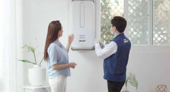 귀뚜라미 제품 서비스 전문가와 고객이 집 안에 설치된 창문형 에어컨 제품에 대해 이야기를 나누고 있다.