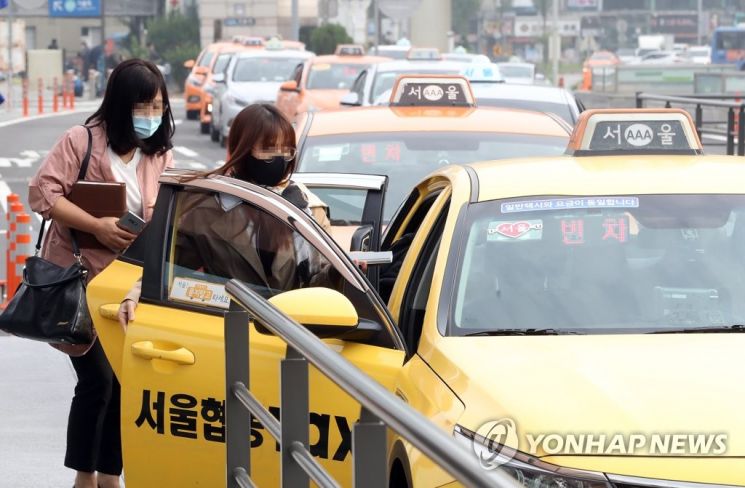 시민들이 마스크를 쓰고 택시에 탑승하고 있다. [이미지출처=연합뉴스]