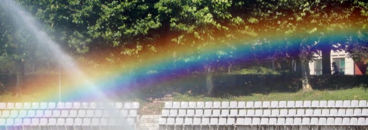 19일 오후 경북 경산시 영남대학교 천연잔디구장에서 더위를 식히려 뿌린 물줄기에 무지개가 나타나고 있다.