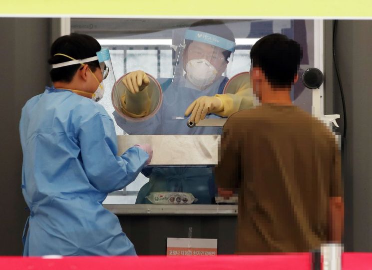 성북구청 앞 바람마당에 설치된 코로나19 선별진료소에서 의료진이 검체 채취를 하고 있다.<이미지:연합뉴스>