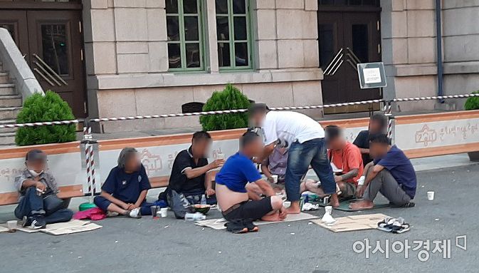 25일 오후 서울역 광장 한쪽에서 노숙인들이 모여 앉아 소주를 마시는 등 음식을 나눠 먹고 있다. 마스크를 착용한 노숙인은 한 명도 보이지 않는다. 사진=한승곤 기자 hsg@asiae.co.kr