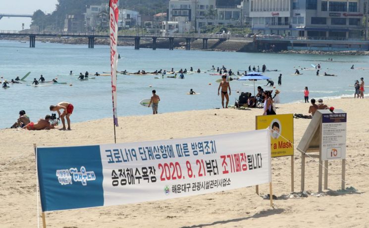 30일 부산 송정해수욕장에서 피서객들이 더위를 식히고 있다. 부산지역 해수욕장은 지난 21일 코로나19 예방 차원에서 조기 폐장했다. [이미지출처=연합뉴스]