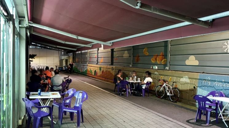지난 31일 오후 10시 서울 동대문구 회기동에 위치한 편의점 앞 야외 테이블에서 고객들이 술을 마시고 있다. 코로나19 감염 우려 탓에 평소보다 테이블 간 거리는 멀어졌지만 마스크를 쓰고 있는 이들은 찾아볼 수 없었다.