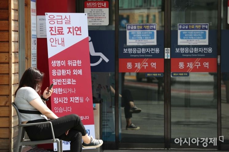 4일 서울 종로구 서울대병원에 설치된 응급실 진료 지연 안내문 앞에서 한 시민이 대기하고 있다. /문호남 기자 munonam@