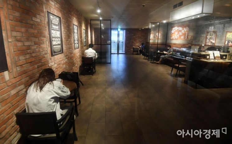 코로나19 재확산으로 강화했던 사회적 거리두기가 2단계로 하향 조정된 14일 서울 시내의 한 프랜차이즈형 커피전문점에서 시민들이 거리를 두고 매장 내 좌석을 이용하고 있다. 정부의 거리두기 2단계 하향 조정에 따라 프랜차이즈형 카페와 제과제빵·빙수점 등은 예전처럼 자리에 앉아 이용할 수 있게 된다. 오후 9시 이후 포장·배달만 허용되던 일반음식점·휴게음식점·제과점도 시간에 관계없이 매장 내에서 음식을 먹을 수 있게 된다./김현민 기자 kimhyun81@