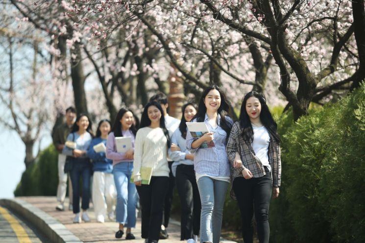 벚꽃 핀 오정동 캠퍼스에서 재학생들이 밝은 표정으로 걷고 있다. 한남대 제공