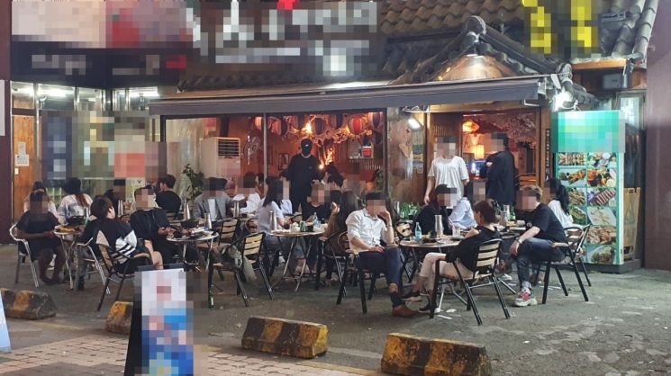 14일 오후 10시께 서울 강남구의 한 술집. 실내는 물론 야외테이블까지 술을 마시는 시민들로 가득 찼다. 이들 중 대부분은 마스크를 반쯤 내리거나 아예 쓰지 않은 채 음주를 즐기고 있었다.