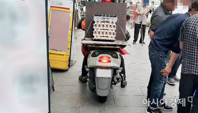 지난 6월 서울 한 번화가에서 배달용 오토바이가 짐을 싣고 인도로 주행하고 있다.사진=한승곤 기자 hsg@asiae.co.kr