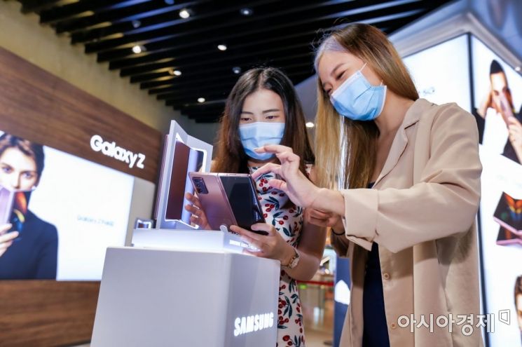 싱가포르의 유명 쇼핑센터 비보시티에 위치한 삼성 익스피리언스 스토어(Samsung Experience Store)에서 현지 소비자들이 '갤럭시Z폴드2'를 체험하고 있다.(사진제공=삼성전자)