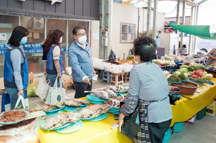 이종호 본부장이 북면 흥부시장에서 직원들과 장을 보는 있는 모습.