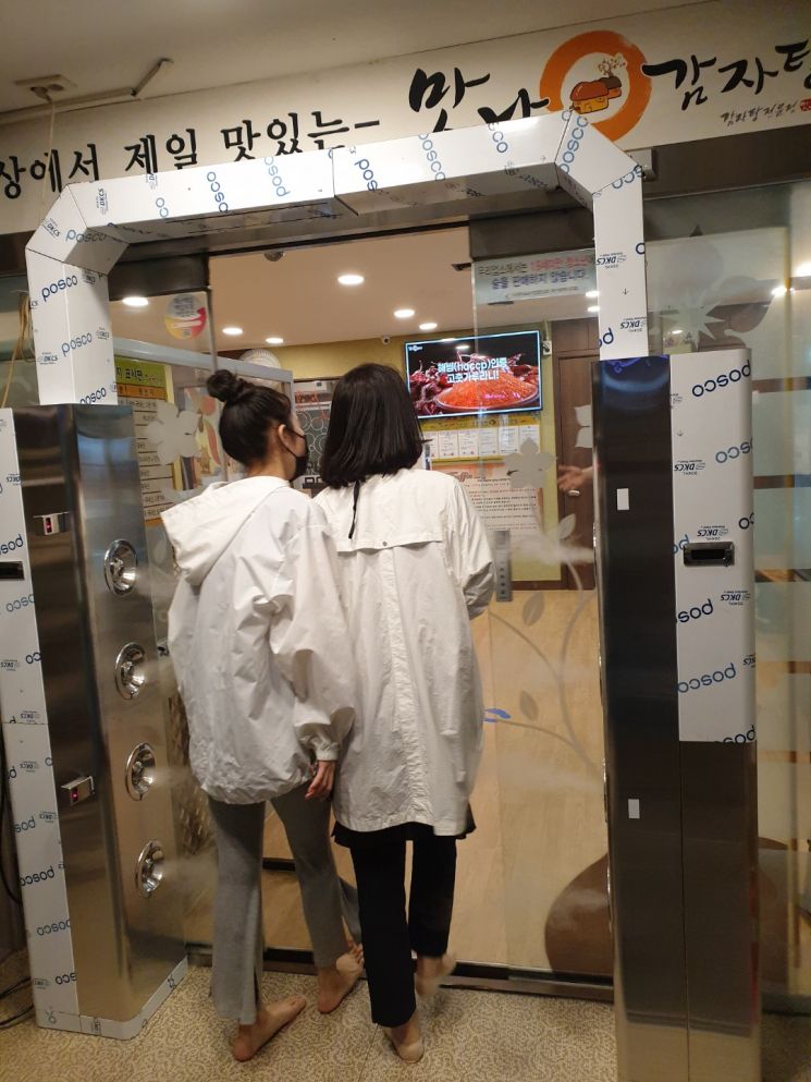 맛나감자탕 부산 화명점. 터널식 전신소독기가 매장 입구에 설치돼 방문객이 드나들 때마다 살균수를 분사해 바이러스 오염원을 제거한다.