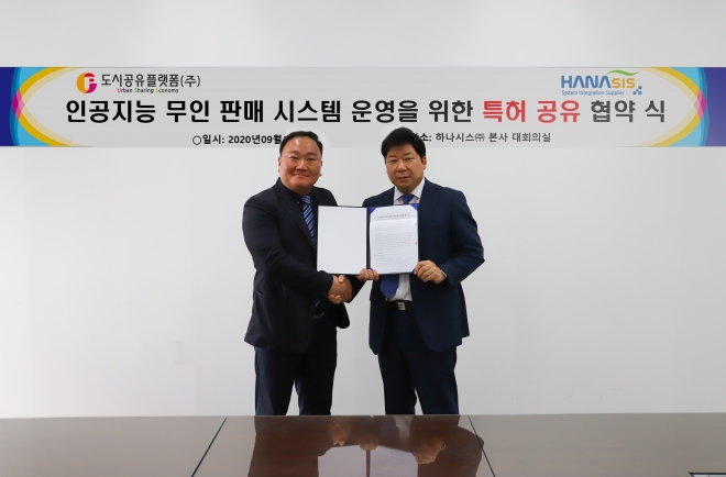 박진석 도시공유플랫폼 대표(왼쪽)와 하나시스 이정용 대표가 특허공유 협약서를 들어 보이고 있다.