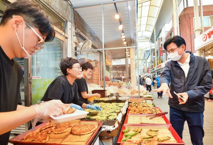 박성수 송파구청장(오른쪽)이 지난 18일 새마을시장을 방문, 전을 구매하고 있다.
