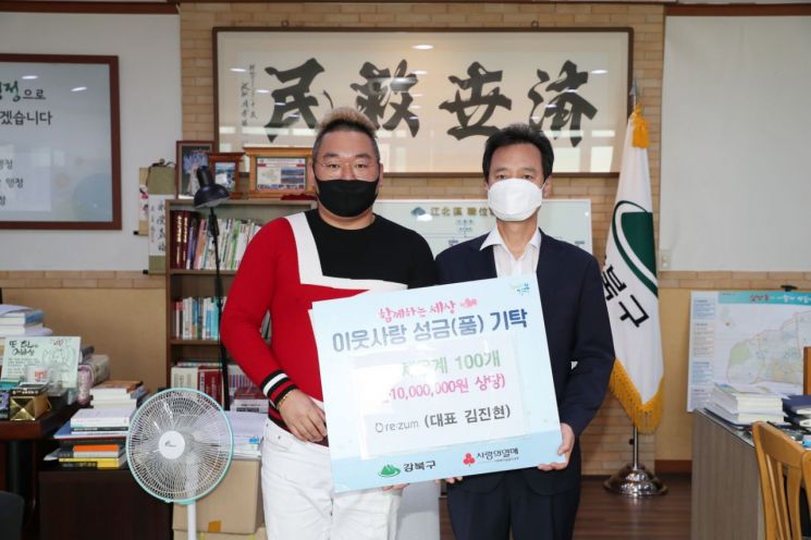 김진현 리쥼 대표(왼쪽)가 비접촉식 체온계을 박겸수 강북구청장에게 전달했다.