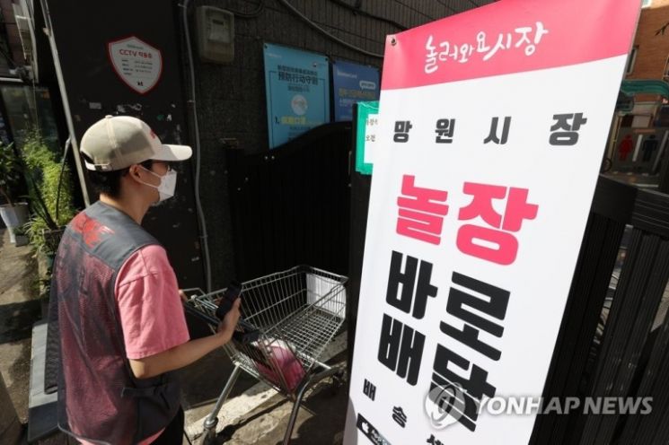추석을 앞둔 지난 24일 오후 서울 마포구 망원 월드컵시장에서 전통시장 배달 서비스 앱 '놀장' 픽업 매니저가 주문된 물건을 받기 위해 이동하고 있다.(사진=연합뉴스)