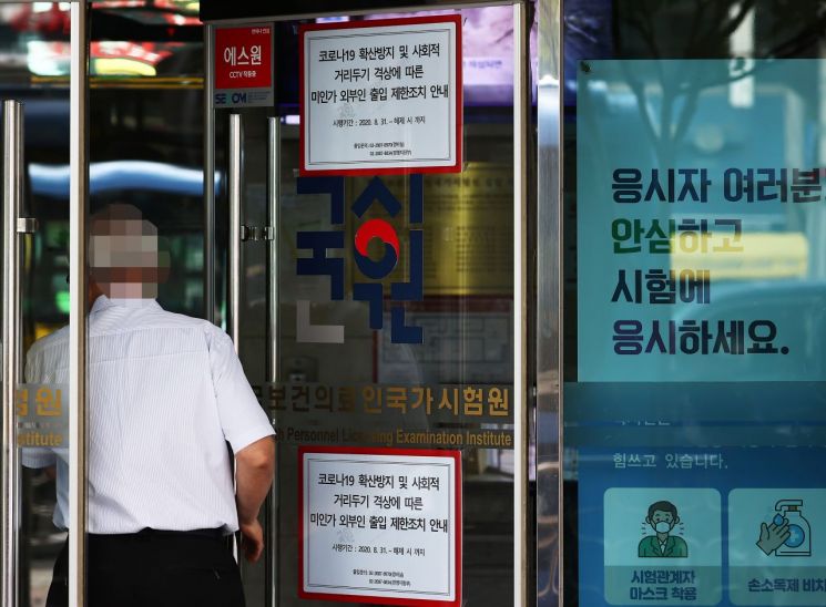전국 의과대학 본과 4학년생들이 기존의 입장을 바꿔 국가고시 응시 의사를 표시한 지난달 24일 자양동에 위치한 한국보건의료인국가시험원(국시원)에 관계자가 출입구를 관리하고 있다/사진=연합뉴스