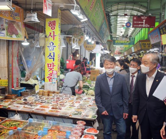 조봉환 소상공인시장진흥공단 이사장(오른쪽)이 전통시장을 방문해 관계자들과 점포를 살펴보고 있다.