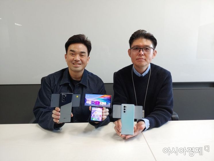 LG전자 MC사업본부 상품기획담당 홍신태 책임과 지훈준 책임이 LG 윙을 들고 기념 촬영을 하고 있다.