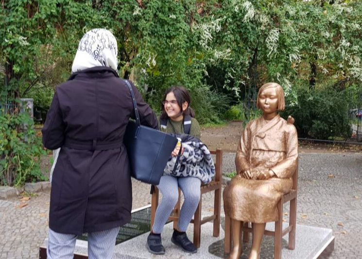 2020년 9월 27일 독일 수도 베를린에 설치된 '평화의 소녀상' 옆에 한 소녀가 앉아있다. [이미지출처=연합뉴스]