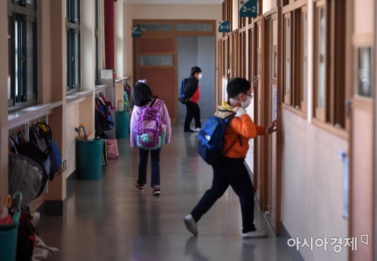 사회적 거리두기 1단계 조정에 따라 전국 유·초·중·고 등교수업이 확대된 19일 서울 금천구 문백초등학교 교실 앞에서 담임교사가 등교하는 아이들의 체온을 측정하고 있다. 교육계에 따르면 이날부터 전국 모든 지역의 등교 인원을 3분의 2로 확대하기로 했다. 수도권 학교와 과대학교·과밀학급은 이 기준을 준수해야 하지만 비수도권은 여건에 따라 밀집도를 조정할 수 있도록 길을 열어놔 모든 학생이 매일 학교에 가는 '전면 등교'도 가능해졌다./김현민 기자 kimhyun81@