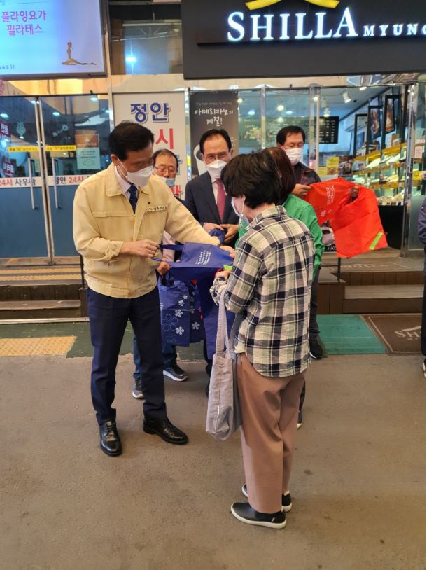 이승로 성북구청장(왼쪽)이 길음전통시장에서 환경사랑 캠페인을 펼치고 있는 성북구 새마을부녀회원들을 응원하고 있다.