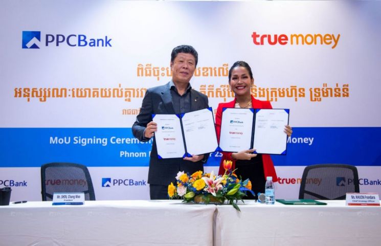 신창무 프놈펜상업은행장(왼쪽)이 태국 전자결제업체 ‘트루머니’와 전자결제 대출 상환 업무협약(MOU)을 체결하고 기념촬영을 하고 있다.