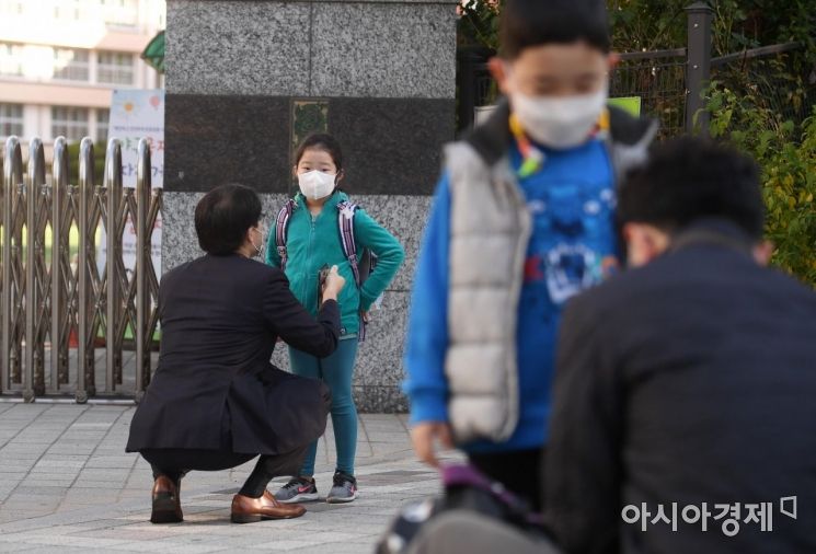 서리가 내린다는 절기 상강(霜降)이자 올가을 가장 쌀쌀한 날씨를 보인 23일 서울 서초구의 한 초등학교 앞에서 부모들이 등교하는 아이들의 옷매무새를 고쳐주고 있다. 기상청은 이날 전국 대부분 지역의 아침 기온이 5도 내외로 떨어지고 낮 기온은 15도 이하에 머물 것으로 예보했다./김현민 기자 kimhyun81@
