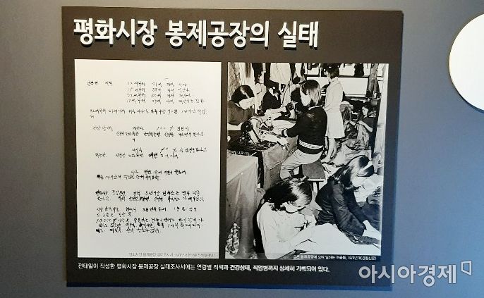 당시 평화시장 봉제공장의 비참한 노동 환경을 설명해주는 글. 사진 속 소녀들이 다닥다닥 붙어 앉아 쉴새 없이 일 하고 있다.사진=한승곤 기자 hsg@asiae.co.kr