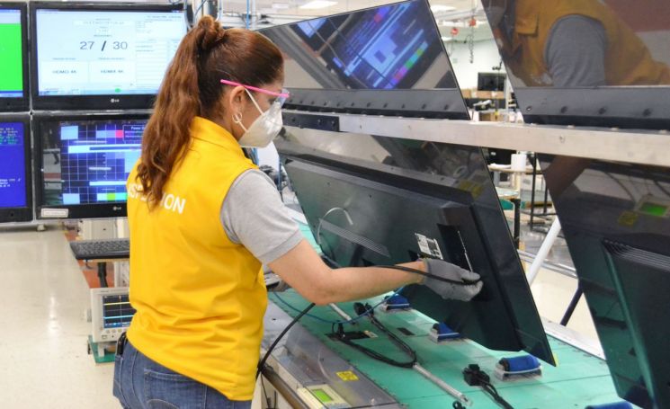 An LG Electronics employee is producing an LG OLED TV (model 65CX) on the TV production line located in Reynosa, Mexico.