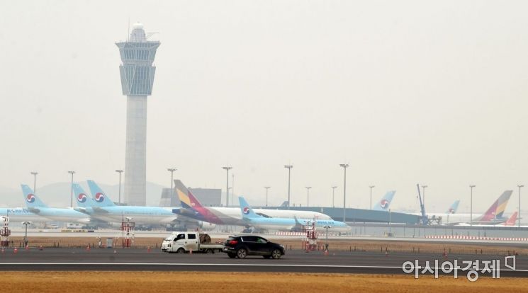 대한항공이 아시아나항공 인수에 나선 가운데 17일 인천국제공항 제4활주로 공사현장 뒤로 대한항공과 아시아나항공 여객기들이 세워져 있다. /문호남 기자 munonam@