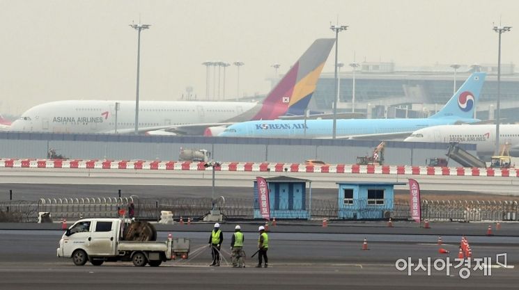 대한항공이 아시아나항공 인수에 나선 가운데 17일 인천국제공항 제4활주로 공사현장 뒤로 대한항공과 아시아나항공 여객기들이 세워져 있다. /문호남 기자 munonam@
