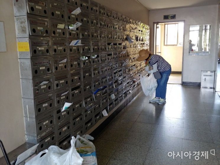경산시보건소 직원이 국가암 검진 안내 편지를 아파트마다 전달하고 있는 모습.