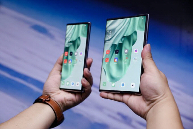 중국 기업 '오포'가 지난달 17일(현지시간) 공개한 세계 최초 롤러블 스마트폰 시제품 '오포X 2021'. 특정 버튼을 누르면 기기 내부에 말려 있던 디스플레이가 펼쳐지면서 스마트폰이 늘어나는 방식. / 사진=오포 트위터 캡처