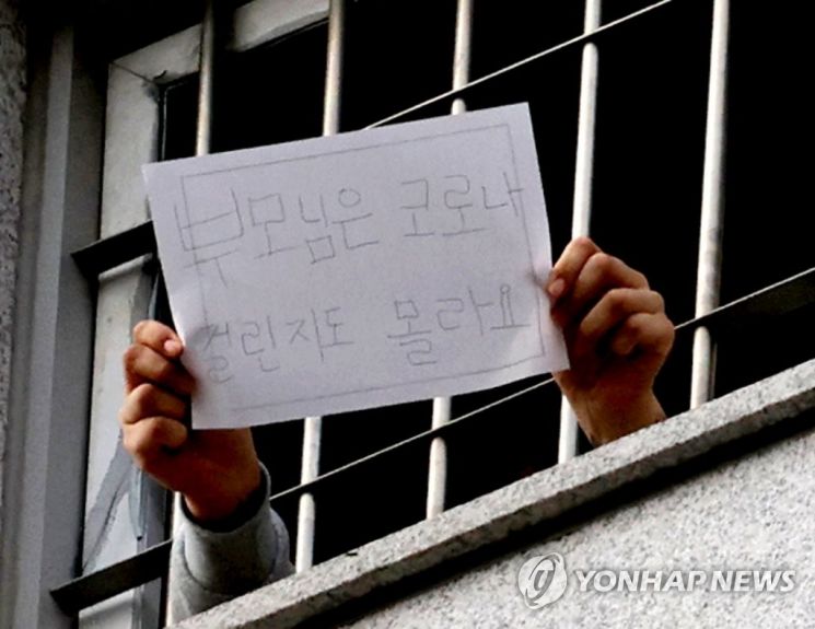 On the afternoon of the 3rd, an inmate at the Dongbu Detention Center in Songpa-gu, Seoul, where a large number of new coronavirus infection cases are occurring, is showing a hand sign to the press. <br>[Image source=Yonhap News]