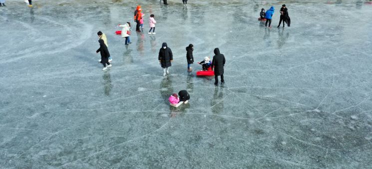 전국에 강추위가 이어진 3일 경북 경산시 남천에서 시민들이 흐르던 물이 얼며 만들어진 자연 얼음썰매장에서 연휴의 마지막 날을 즐기고 있다. [이미지출처=연합뉴스]