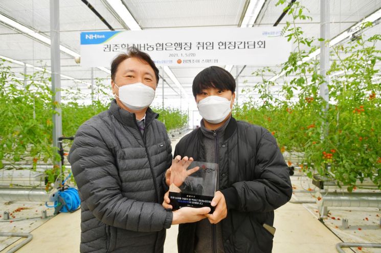 NH농협은행 권준학 은행장(좌측)이 5일 충남 아산시에 위치한 팜엔조이 농장을 방문한 후 박세근 대표(우측)와 기념촬영을 하고 있다.