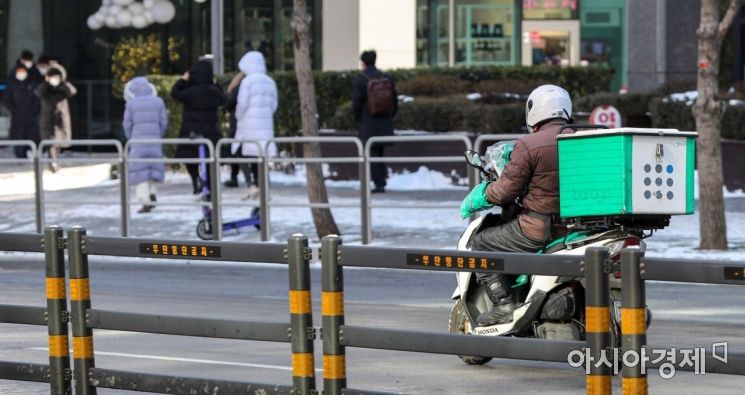 On the 7th, when the temperature in Seoul dropped to minus 15 degrees Celsius and a cold wave warning was issued, a motorcycle delivery worker set out for deliveries during lunchtime on Seosomun-ro, Jung-gu, Seoul. Photo by Jinhyung Kang aymsdream@