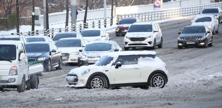 7일 오전 서울 강남구 영동대로에서 한 차량이 눈에 갇혀 움직이지 못하고 있다. [이미지출처=연합뉴스]